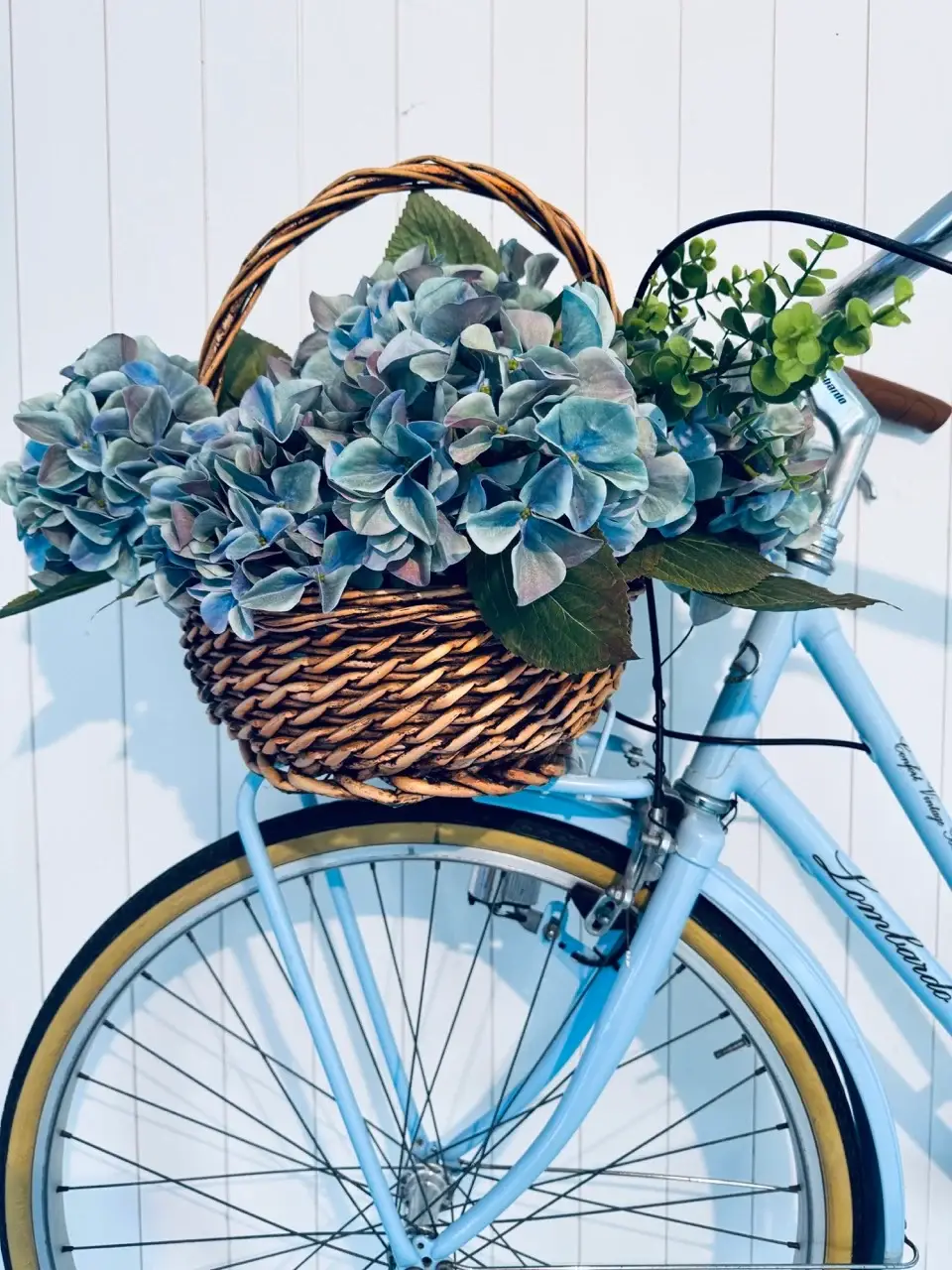 front of a bicycle with beautiful flowers in a retro basket.